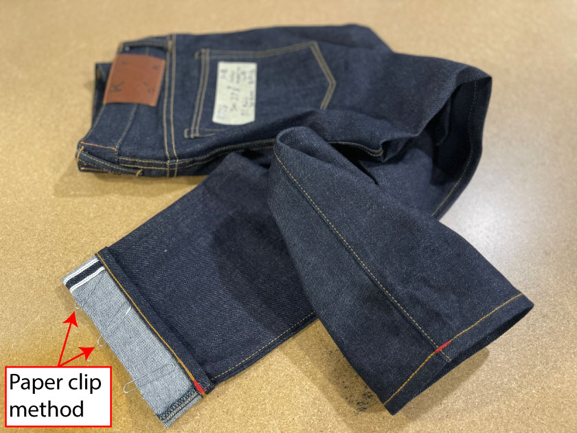 Image of Hiroshi Kato jeans shows how to take note of your jean's inseam length with a paper clip if you don't have a tape measure
