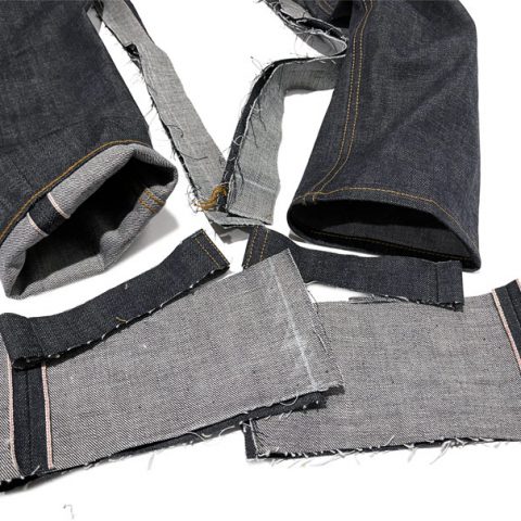 The hem of tailored jeans next to parts of the original leg size shows an example of what it means to have "tapered jeans alterations."