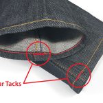 A close-up of two red bar tacks stitched onto the hem of a pair of Gustin jeans highlights what a bar tack is.