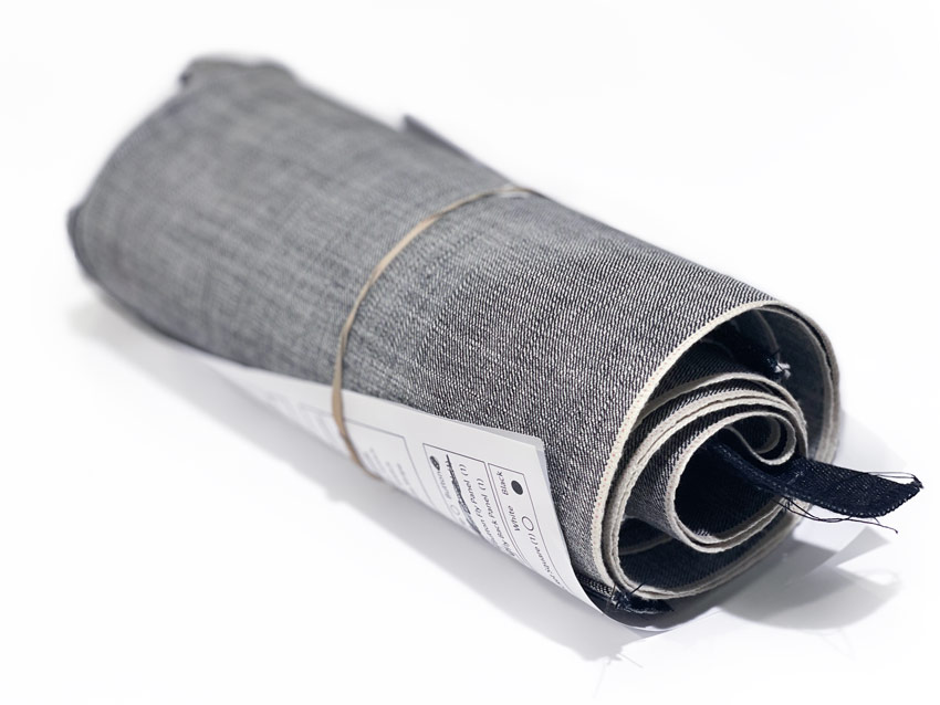 Selvedge denim fabric parts are rolled up to later be sewn into a pair of custom, handmade selvedge denim jeans by Williamsburg Garment Company.