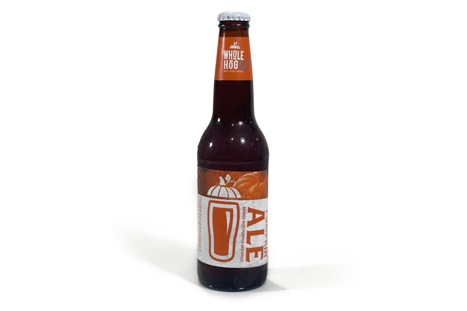 A 12-ounce bottle of Whole Hog Brewery's Pumpkin Ale, set against a neutral background, ready for tasting review on the blog 'Denim Beer Machines & Coffee'.