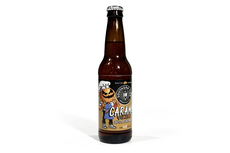 This image displays a 12 oz bottle of Southern Tier Brewing Company’s Caramel Pumking Imperial Pumpkin Ale, highlighting the label’s distinct pumpkin-themed design. The beer, known for its strong caramel, pumpkin, and spice flavors, has a higher alcohol content (8.6% ABV) and appeals to those who enjoy sweet, dessert-like beers. The pumpkin-headed mascot on the label emphasizes the playful and seasonal aspect of this imperial ale.