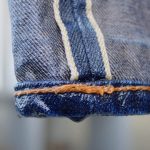 Close-up of wet raw denim jeans after washing, highlighting proper denim care techniques.