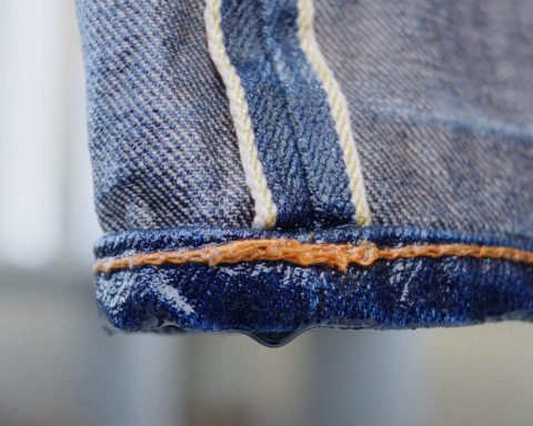 Close-up of wet raw denim jeans after washing, highlighting proper denim care techniques.