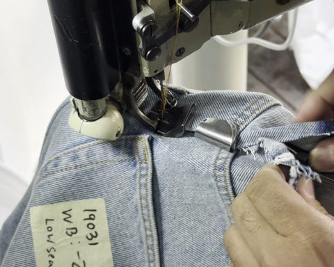 Close-up of sewing the center back seam on denim to take in the waist of jeans using a Union Special feed-off-the-arm machine with chainstitching.