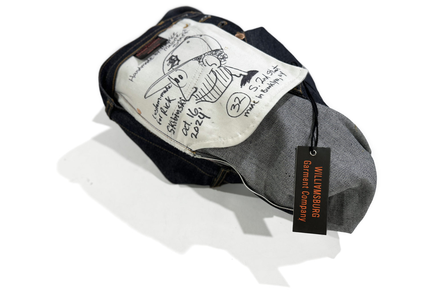 Signed handmade jeans with illustrated pocket bag and Williamsburg Garment Company tag, representing the upcoming denim workshop where attendees learn how to make jeans.