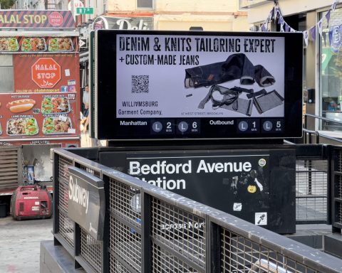 Subway billboard at Bedford Avenue Station featuring Williamsburg Garment Company’s denim tailoring and knitwear alteration ad above the L Train entrance.