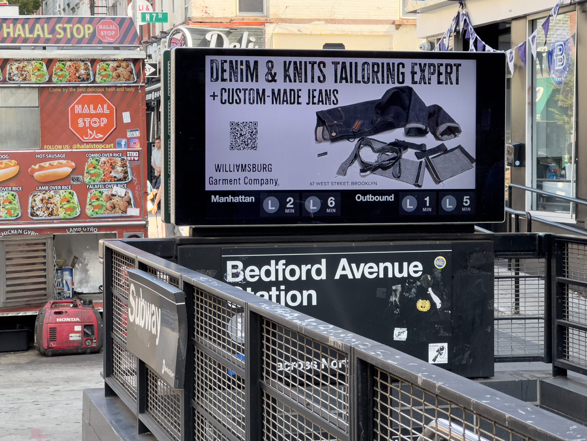 Subway billboard at Bedford Avenue Station featuring Williamsburg Garment Company’s denim tailoring and knitwear alteration ad above the L Train entrance.