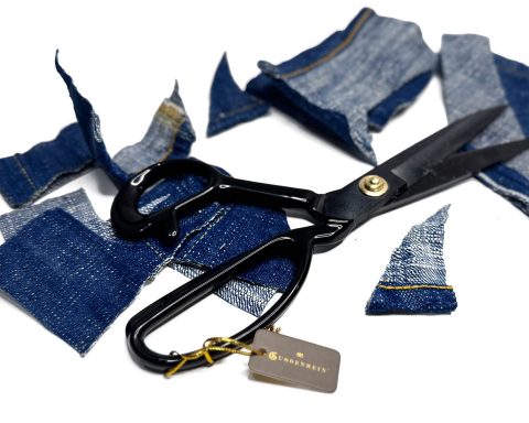 Guggenheim shears surrounded by freshly cut denim fabric pieces, demonstrating professional scissors for cutting denim.